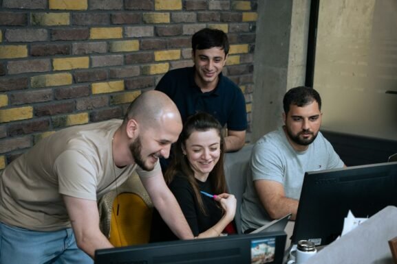 Professionals discussing ideas together around a laptop during a collaborative session