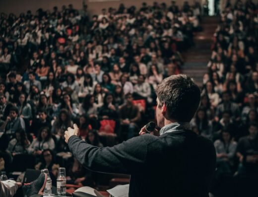 Speaker presenting confidently to an audience during a public speaking session